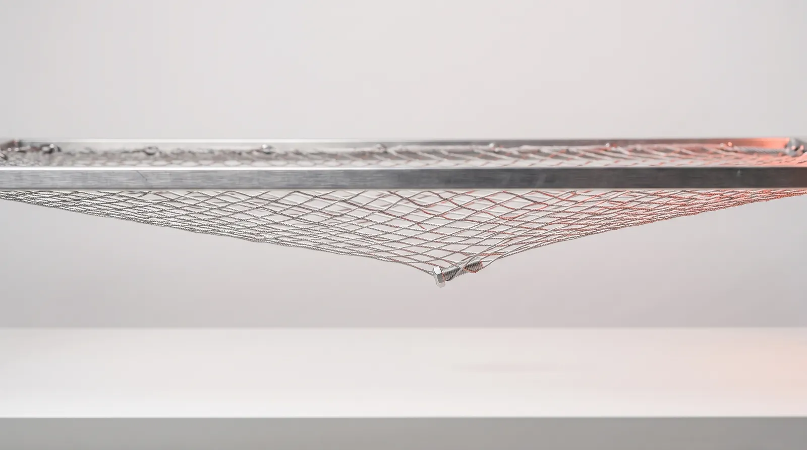 Un filet tendu au-dessus d'un établi dans le noir, éclairé par une seule lumière corail rasante