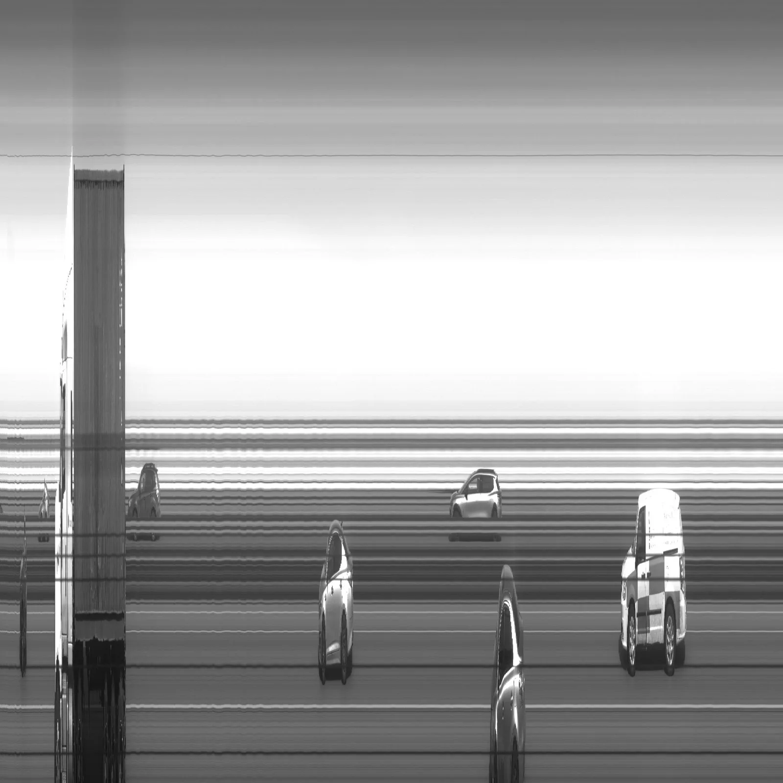 Image produite depuis un train : des voitures à l'arrêt apparaissent étirées ou écrasées, le décor se réduit à des bandes horizontales, et une colonne verticale marque un objet immobile devant l'objectif